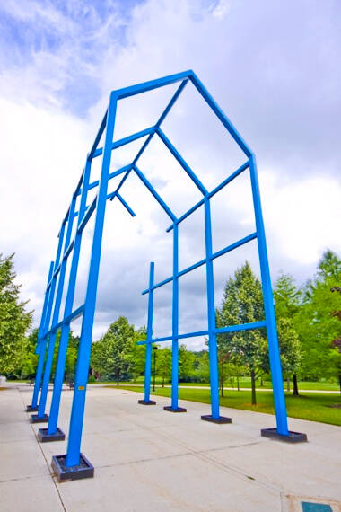 Large, blue, outdoor sculpture that looks like an arch.